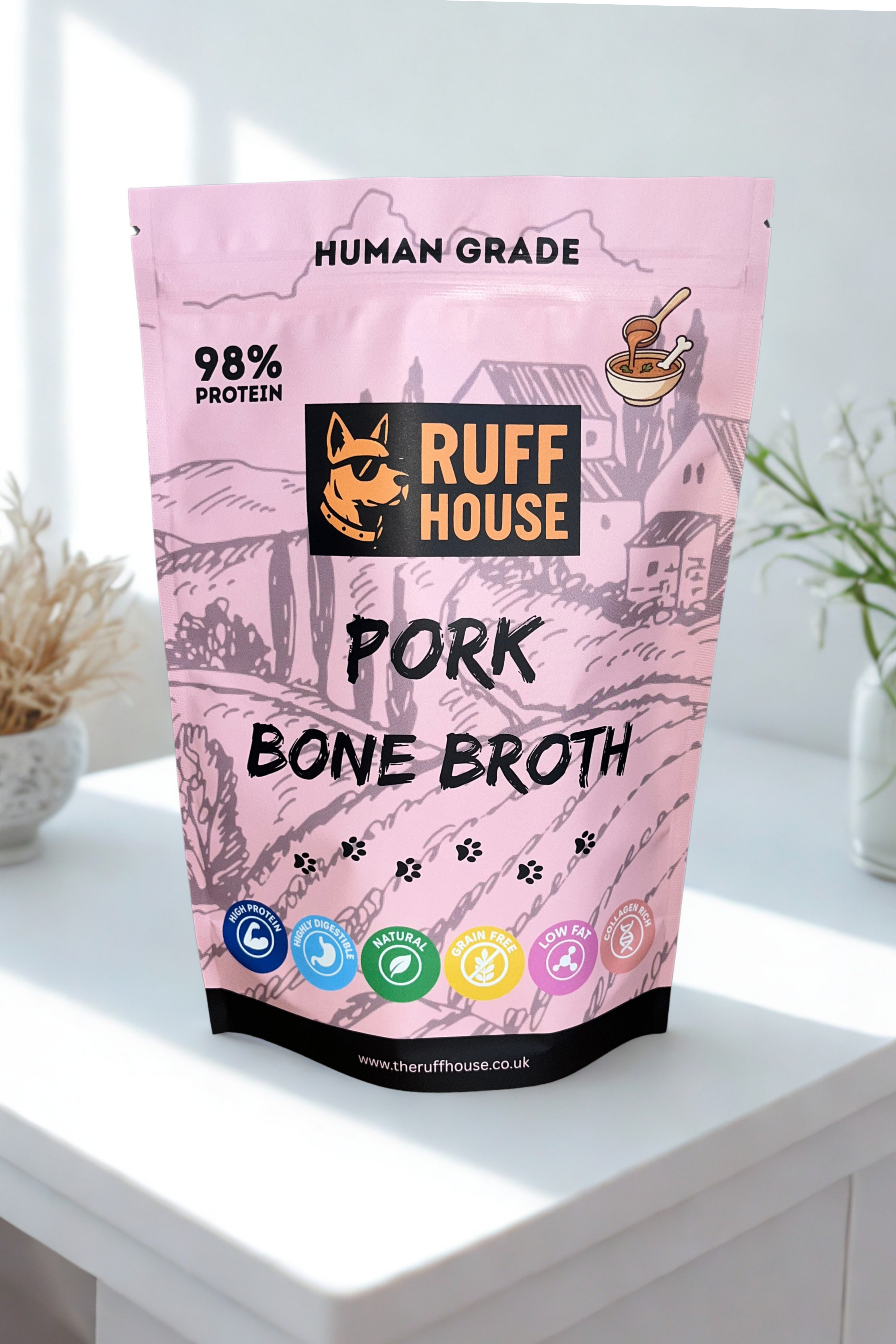 Ruff House Pork Bone Broth front of pack showing the pink human grade 98 percent protein powder topper designed to support joints, boost hydration, and add savoury pork flavour to dog meals.